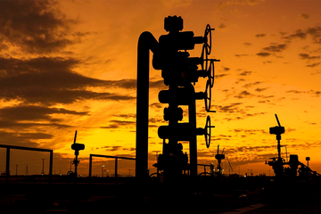 Photo of oil production christmas tree at sunset.
