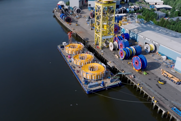 Arial photo of some Baker Hughes flexible pipe being loaded on a barge.