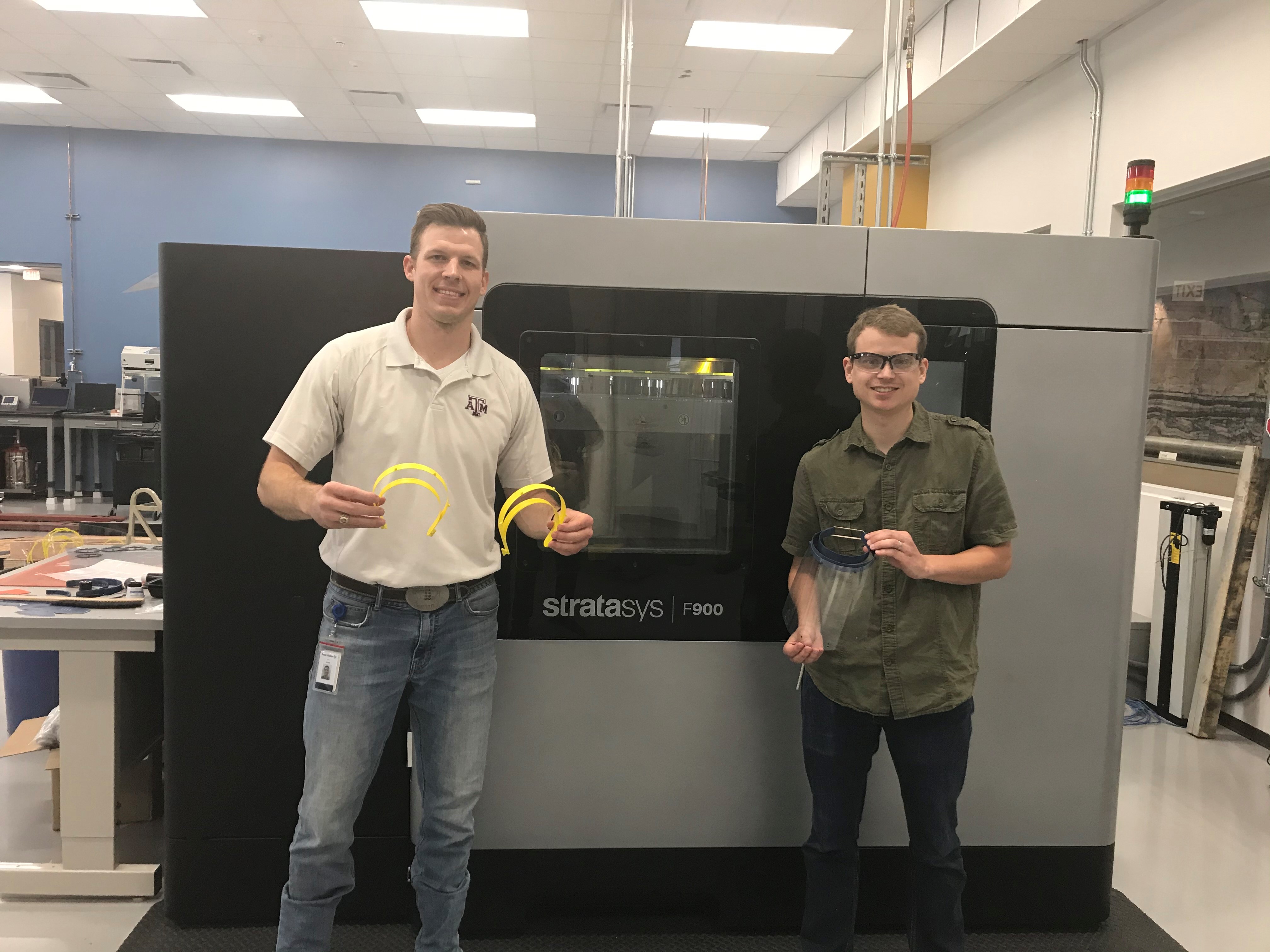 Two male Baker Hughes employees demonstrating 3D printed medical equipment