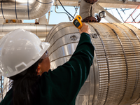 Photo of Baker Hughes engineer taking temps at a refinery.