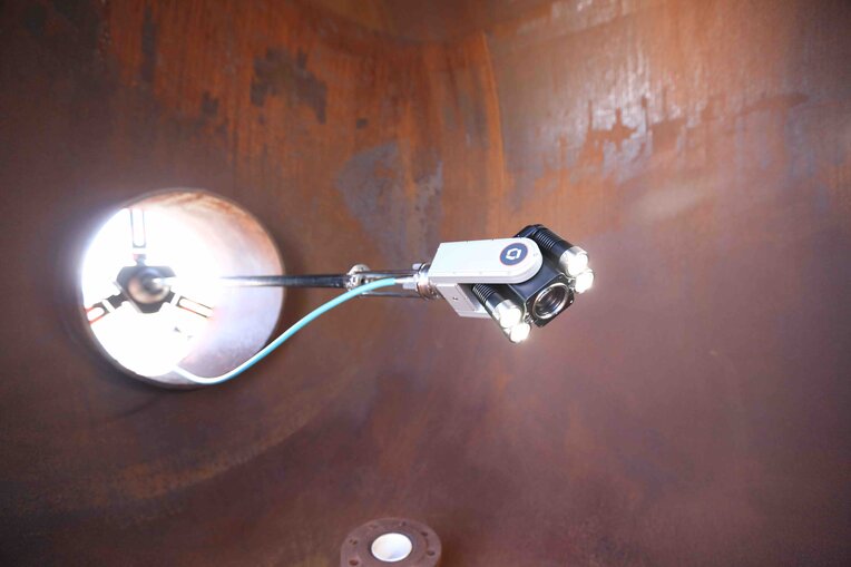 Close up image of ca-zoom hd ptz inspection camera head extended and held up by its industrial mount that attaches to the outside of the vessel access point.