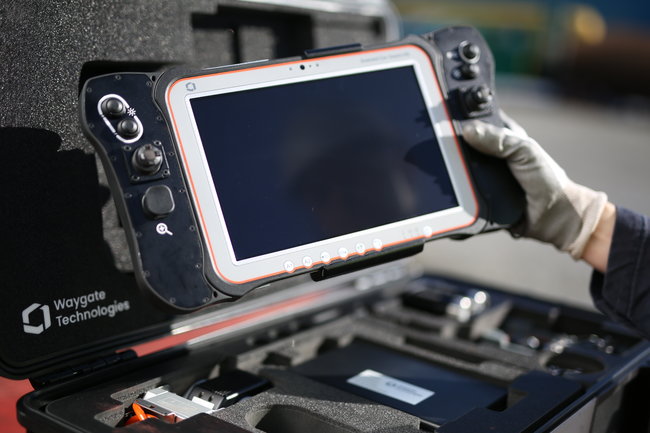 Technician holding the Everest Ca-Zoom HD inspection camera operating tablet.