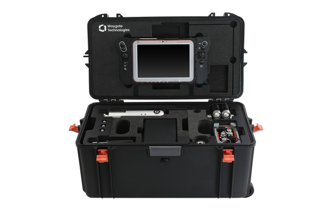 Open black protective case containing Waygate Technologies industrial inspection equipment, including a branded tablet, cables, cylindrical tools, and specialized components—used for remote visual inspection (RVI) in nuclear and industrial applications.