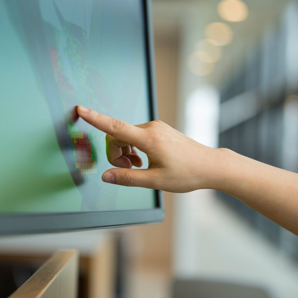 a person pointing at a screen conducting remote services
