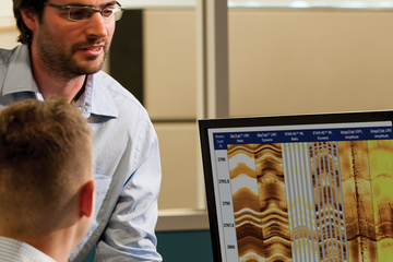 Men look at image log on computer screen