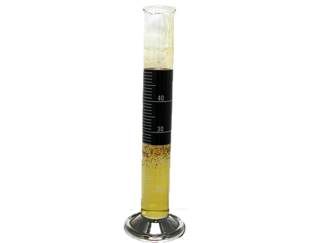 Photo of a beaker showing the separation of contaminated drilling fluid.