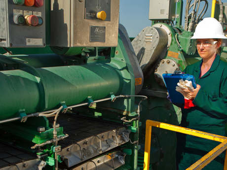 Photo of a Baker Hughes employee checking equipment on the rig site.