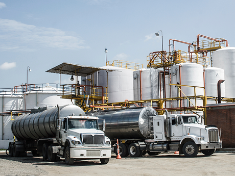 Photo of two trucks at a refinery.