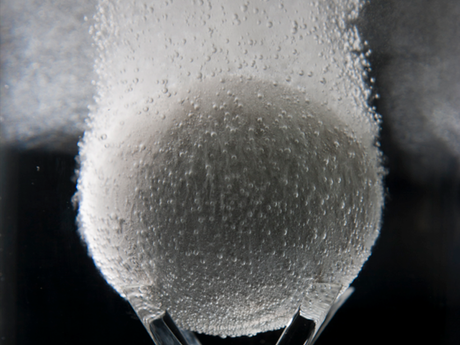 Photo of an In-Tallic disintegrating frac ball disintegrating in liquid.