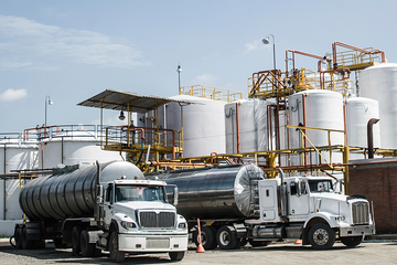 Photo of two trucks at a refinery.
