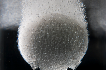 Photo of an In-Tallic disintegrating frac ball disintegrating in liquid.