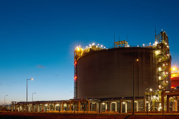 Liquefied natural gas (LNG) storage tank installation at dusk.