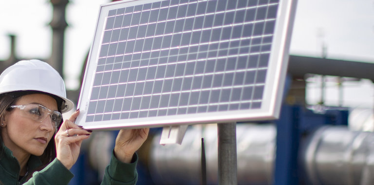 Baker Hughes employee inspecting solar panal