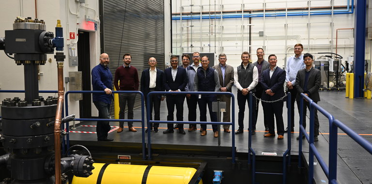 Wells2Watts consortium board members stand next to the Baker Hughes laboratory test well that will be repurposed to evaluate the closed-loop geothermal system at the at the OSU Hamm Institute of American Energy, Oklahoma City, Okla.