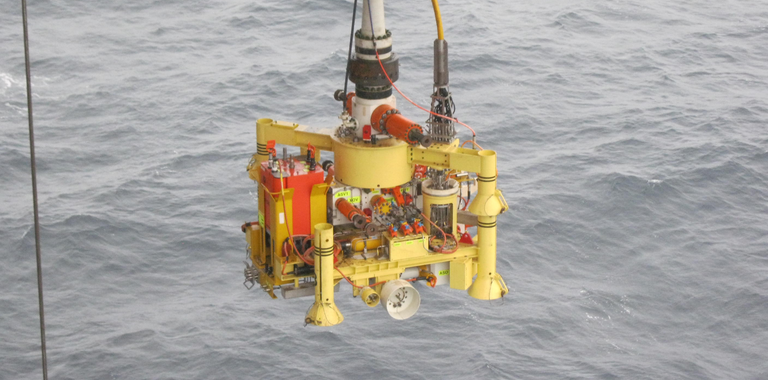 Photo of a subsea tree being lowered into the ocean.
