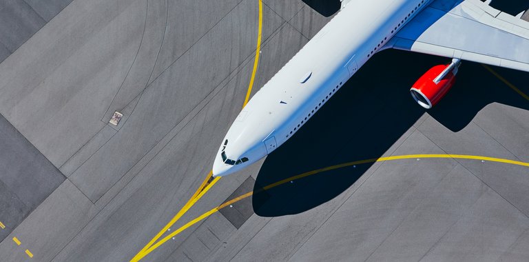Image of large commercial aircraft lining up on the runway to take off.