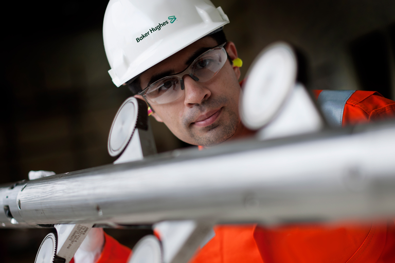 Photo of a Baker Hughes engineer inspecting a tool.