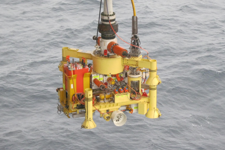 Photo of a subsea tree being lowered into the ocean.
